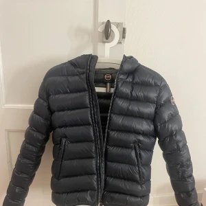 Mörkblå dunjacka från Colmar - ‼️kan tänka mig 2600kr vid snabb affär ‼️Säljer en snygg svart dunjacka från Colmar i mycket bra skick. Jackan har en dragkedja framtill och en praktisk huva. Perfekt för kyliga höst- och vinterdagar. Den är lätt och bekväm att bära, med en stilren design som passar till det mesta. Storlek 40, motsvarar ca xxs/xs 