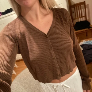 Brun ribbad kofta från Brandy - Säljer en superfin brun ribbad kofta med knappar framtill. Den är croppad och har långa ärmar, perfekt för en avslappnad stil. Passar bra till både vardag och mysiga hemmakvällar. 🧡Köpt på Brandy Melville