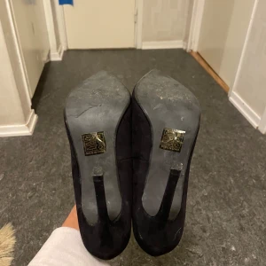 Svarta pumps från Only - Snygga svarta pumps i mocka från Only med spetsig tå och klack. De har en unik vågig kantdetalj som ger en extra touch av stil. Perfekta för festliga tillfällen eller en utekväll. Använd en gång.