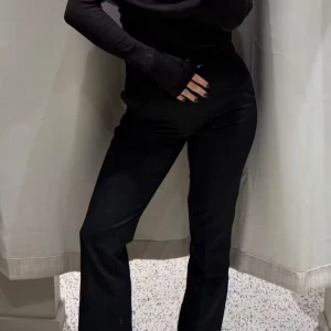 Svarta kostymbyxor - Snygga svarta kostymbyxor i medelmidja. Perfekta för både kontoret och festliga tillfällen. De har en klassisk straight passform och är tillverkade i ett bekvämt material som ger en stilren look. Ett måste i garderoben för en elegant stil!