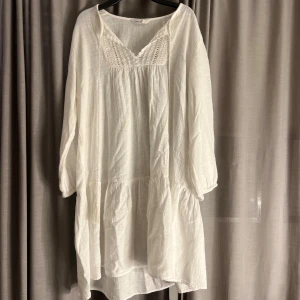 Superfin sommarklänning  - Säljer en superfin vit klänning från Gina Tricot. Den har en v-ringad design med spetsdetaljer och långa ärmar. Perfekt för sommarens alla fester eller en mysig dag på stan. Klänningen är i ett luftigt material som känns skönt mot huden.