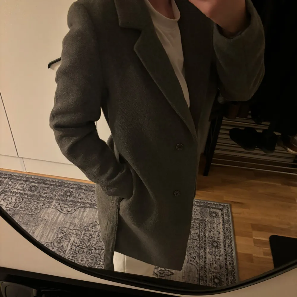 Säljer en stilren grå kappa från H&M i storlek S. Den har ett bälte i midjan, perfekt för höst och vår. Kappan är i mycket bra skick och passar både till vardags och fest. kappan är i jätte bra skick då den bara är använd 1 gång! . Jackor.