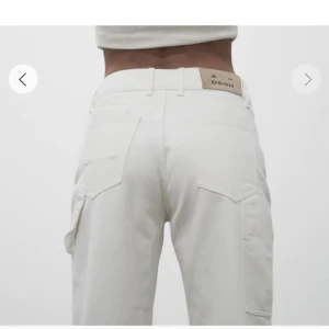 Vita byxor från A_DSGN - Säljer ett par snygga vita byxor från A_DSGN i storlek 40. En ”cargo” liknande byxa. Använt 1 gång. Passar 36-40 beroende på passform