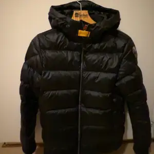 ÄKTA!!Säljer en snygg svart pufferjacka från Parajumpers i mycket bra skick i modellen SHEEN. Jackan har en quiltad design med långärmade ärmar och en praktisk dragkedja framtill. Perfekt för kalla vinterdagar med sin varma och bekväma passform. Jackan passar både S och M