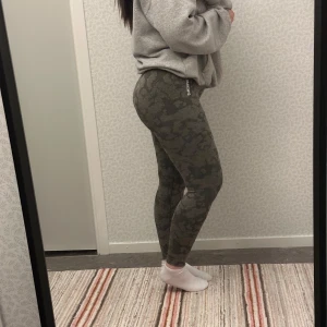 Camo leggings från Gymshark - Snygga grå camo leggings från Gymshark. Perfekta för träning med en tight passform som framhäver dina former. De har en väldigt subtle ”skrunch” i bak. Är storlek M, men passar även L.