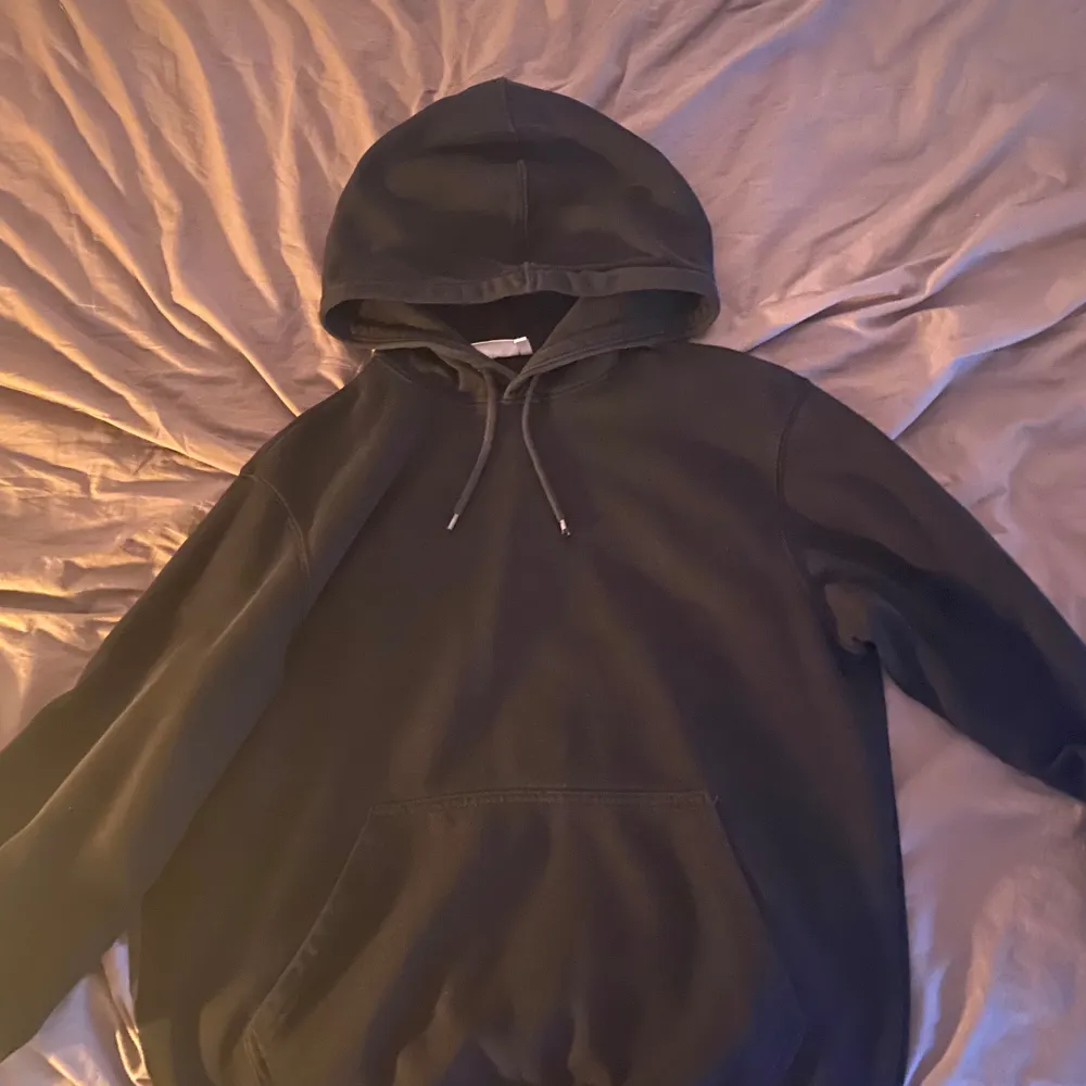 Säljer en klassisk svart hoodie med luva . Perfekt för en avslappnad stil. Den har en rymlig ficka framtill och är tillverkad i ett mjukt material.. Neuletakit & Villapaidat.