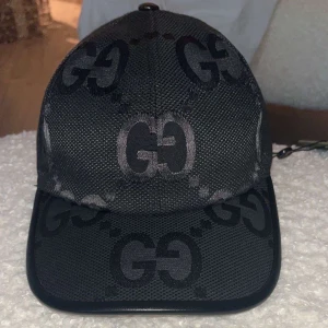 Gucci jumbo keps - Snygg svart keps från Gucci med det ikoniska GG-mönstret. Kepsen har en justerbar rem baktill för perfekt passform. Perfekt accessoar för en stilren look. Pris kan diskuteras vid snabb affär!!