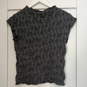 Grå topp med textur - Festtopp från Gina Tricot