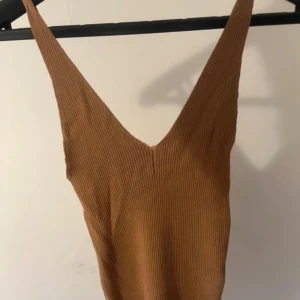 V-ringat linne - V-ringat linne med ribbat material och svala axelband.🤎