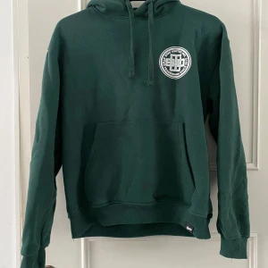 Grön hoodie från Stay United - Säljer en snygg grön hoodie från Stay United med stort tryck på både fram- och baksidan. Hoodien har en klassisk design med känguruficka och justerbar huva. Perfekt för en avslappnad stil!