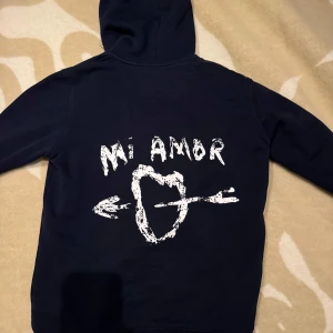 Mi Amor hoodie  - Säljer min trediga Mi Amor hoodie i marinblå färg! Super bra skick fortfarande eftersom jag inte har använt den så mycket😇 köpt för 1800 ish och den verkar vara slutsåld överallt💕pris kan såklart diskuteras☺️