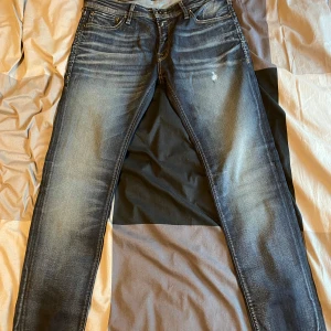 Blå skinny jeans från Jack & Jones - Snygga blå skinny jeans från Jack & Jones med en klassisk femficksdesign. De har en lätt tvättad look och är perfekta för en stilren vardagsoutfit. Säljer dessa par byxor eftersom fick det som en present men tyvärr passade den inte! 