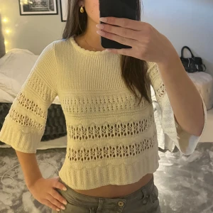 Stickad trekvartsärmad tröja - Säljer en söt vit stickad topp. Den har trekvartsärmar och ett fint hålmönster som ger en luftig känsla. Toppen är croppad och passar perfekt för vår och sommar💕