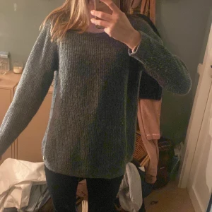 Grå stickad tröja från Three Sixty Five - Mysig grön stickad tröja från Three Sixty Five. Perfekt för kyliga dagar med sin bekväma passform och långa ärmar. Enkelt och stilrent plagg som passar till det mesta. 🧶