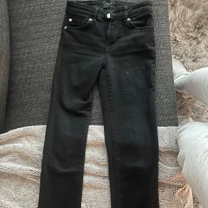 Svarta låg midja jeans från Vero Moda - Snygga svarta jeans från Vero Moda i en klassisk straight fit. De har en låg midja och är perfekta för en stilren look. Jeansen har fem fickor och stängs med dragkedja och knapp.