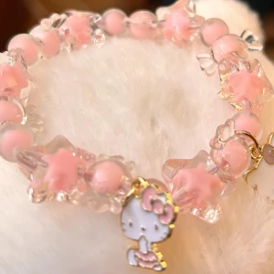 Fint elastiskt armband med berlocker! - Fint elastiskt armband med rosa pärlor och berlocker med Hello Kitty. Nytt!