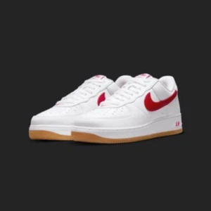 Nike Air Force 1 Low Retro - Klassiska Nike Air Force 1 Low Retro sneakers i vitt med en iögonfallande röd Swoosh. Skorna har en snygg gummisula och snörning för perfekt passform. Perfekta för en stilren look. Helt nya i förpackning, aldrig använda. Köpta på SNKRS.