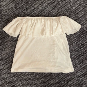 Vit offshoulder topp med volang - Säljer en söt vit offshoulder topp med volangdetaljer. Perfekt för sommardagar eller en brunch! Toppen är i ett mjukt och bekvämt material. Storleken är 134/140 men den passar mig som vanligt har storlek XS/S☺️