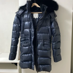 Dunjacka från Boomerang - Snygg och varm svart dunjacka från Boomerang med äkta päls. Köpt för 7000, inte kommit till användning, säljer nu för 2500. Mycket tjock med stor huva perfekt till vintern.