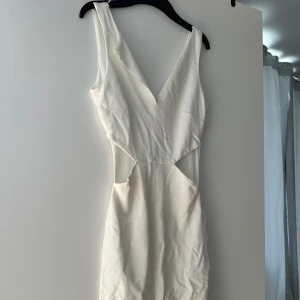Klänning  - Letar du efter det ultimata statement-plagget för ditt nästa evenemang? Sök inte längre! Vår ärmlösa, rygglösa festklänning utstrålar elegans och sofistikering. Med sin eleganta design och smickrande silhuett är denna klänning perfekt för att göra en
