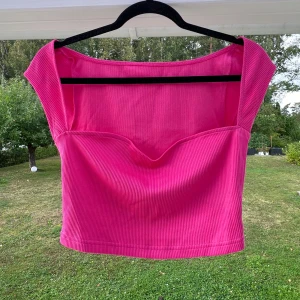 Rosa crop top - En rosa crop top med hjärtskärning. Säljer den pga att den är en aning stor till mig 🩷  (ALDRIG ANVÄND)  Längd: 33 cm Byst: 80 cm