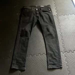 Svarta jeans från Replay - Säljer ett par snygga svarta jeans från Replay i modellen Rocco. De har en klassisk femficksdesign och är i storlek 32. Perfekta för både vardag och fest!