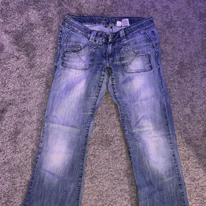 Lågmidjade ljusblå jeans - Ett par väldigt fina raka litte mer baggy jeans, dock är dom inte i topp skick och är lite slitna där nere och har andra smådefekter därav priset. Ko
