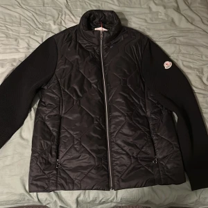 Moncler cardigan - Säljer en snygg svart cardigan/jacka från Moncler. Den har en dragkedja framtill och är långärmad med ett Moncler-märke på ärmen. Perfekt för hös❗️ej org ❗️ är öppen för byten. Jackan är aldrig använd. Byter helst mot en jacka.