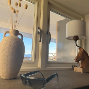 Grå solglasögon från YSL - Snygga grå solglasögon från YSL med en modern, rektangulär form. Glasögonen har en transparent grå båge och mörka linser som ger en cool look. Perfekta för att ge din outfit en stilfull touch.