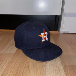 Fitted Hat New Era - Snygg mörkblå keps från New Era med broderad logotyp i orange och vit framtill. Köpt från myhat men säljer den eftersom den är för stor för mig. Väldigt gott skick tho :D