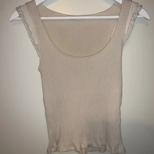 Beige ribbad linnetopp från Zara - Säljer en  beige ribbad linnetopp från Zara som är väldigt fin inför sommarn t.ex! Toppen har spetsdetaljer vid axlarna eller volanger. Den är använd ett fåtal gånger och har inga defekter😄💕