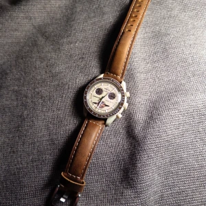 Omega x Swatch Speedmaster mission to saturn - Omega x Swatch Speedmaster Moonwatch med en brun urtavla och tachymeter. Har köpt till ett extra läder armband som följer med klockan följer även med originalbandet, tyvärr har kvittot fått fötter men letar för fullt. hör gärna av er vid frågor!