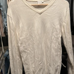 Vit tröja från Club XPRS - Säljer en stilren vit tröja från Club XPRS. Tröjan har en v-ringad hals och långa ärmar, perfekt för en klassisk look. Passar bra till både jeans och chinos.