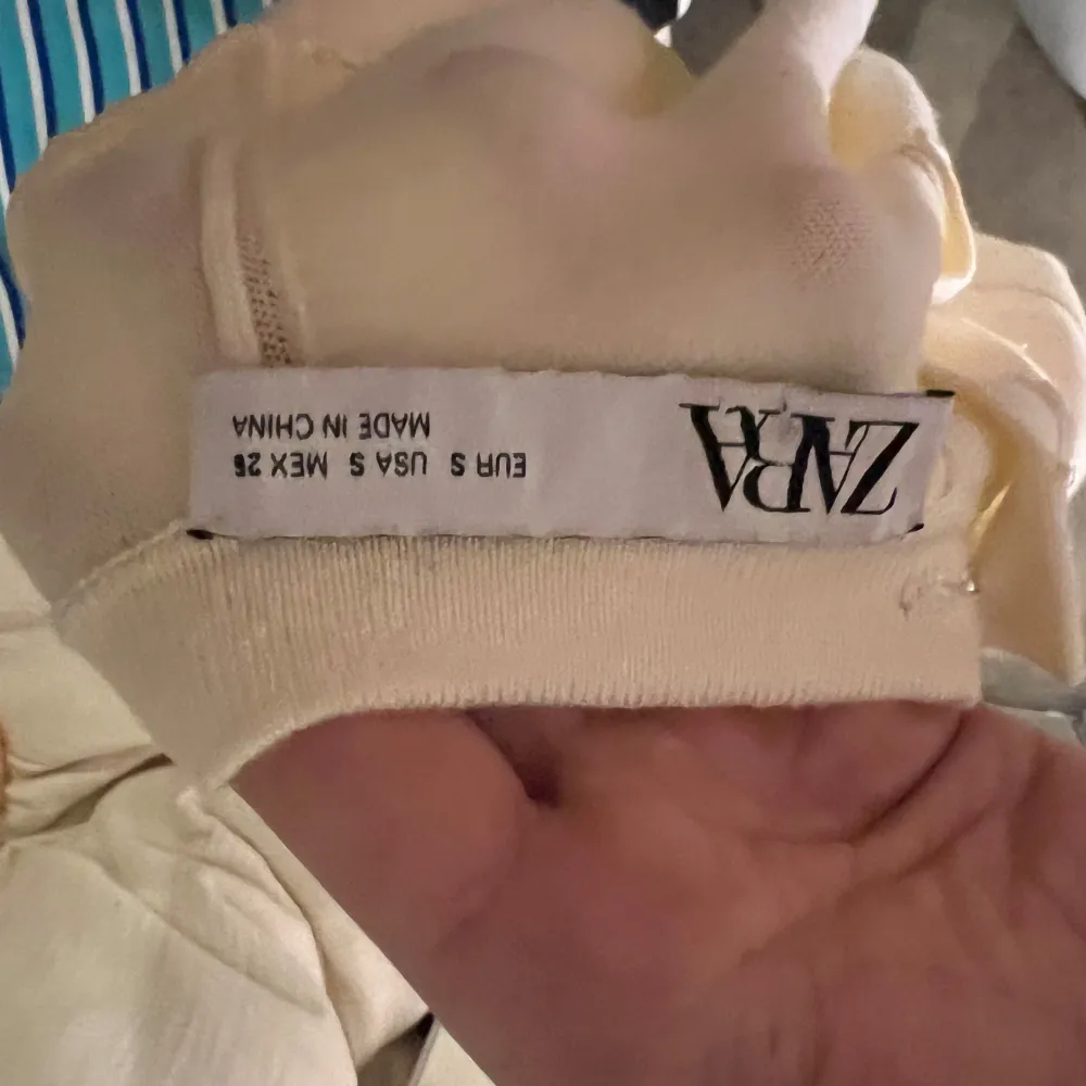 Säljer en stilren beige topp med korta ärmar. Toppen har en enkel design och är perfekt för en avslappnad look. Den är tillverkad i ett mjukt material som känns skönt mot huden.. Yläosat.