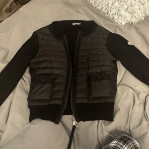 Moncler Cardigan - En svart jätte fin moncler cardigan. Hade inte en så fin och tydlig  bild på tyvärr. Jag säljer pågrund av att jag ska köpa en i en annan färg. Den har inga skador förutom att ettiketten på insidan har lossnat på ena sidan som ni ser. Ni får jätte gärna lägga pris förslag. 