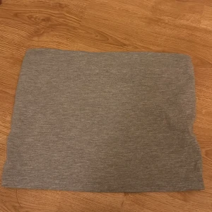 Grå tubtopp från Gina Tricot - Säljer en enkel och stilren grå tubtopp från Gina Tricot. Perfekt för en minimalistisk look och lätt att matcha med olika outfits. Gjord i ett mjukt och bekvämt material.💗