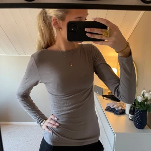Grå långärmad topp - Säljer en stilren grå långärmad topp. Perfekt för en enkel och bekväm look. Passar bra till både jeans och kjol.