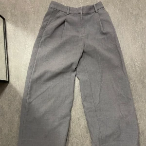 Grå kostymbyxor - Grå kostymbyxor från Monki i storlek 34. Breda i formen 