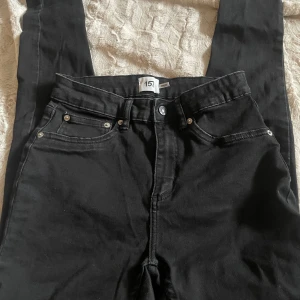 Svarta jeansbyxor från 157 - Snygga svarta jeansbyxor från 157 med klassisk femficksdesign och knappgylf. Perfekta för en stilren look.