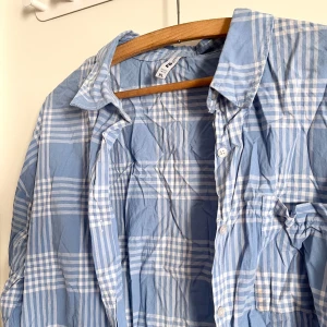 Bomull skjorta - Rutig blå skjorta i bomull, luftig och lätt! Sitter som M. Har använts fåtal gånger. Skjortan har legat i garderoben ett tag och är därför skrynklig på bild, men har inga märken eller fläckar, väldigt bra skick! Plagget tvättas noga innan leverans! Det är bara att skriva om du har några frågor! <3 