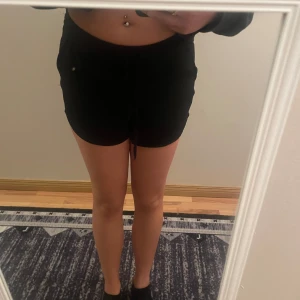 Svarta shorts med knytband - Säljer ett par svarta shorts med knytband i midjan. De är perfekta för en avslappnad stil och har en bekväm passform.