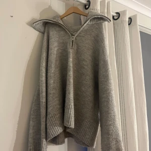 Grå stickad tröja från Bershka - Säljer en grå stickad tröja från Bershka med dragkedja och krage. Inte använd särskilt många gånger, säljer eftersom den inte kommer till användning.
