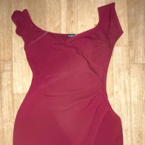 Vinröd klänning  - Snygg vinröd klänning. Perfekt för en kväll ute eller en speciell tillställning. Klänningen har en smickrande passform och en elegant slits.