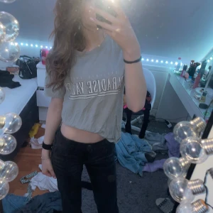 Grå t-shirt från Gina Tricot - Säljer en grå t-shirt från Gina Tricot med texten 'Paradise Valley' tryckt på framsidan. T-shirten har en avslappnad passform och korta ärmar. Perfekt för en casual look.