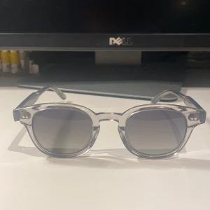 Grå transparenta solglasögon Chimi 01 - Snygga grå transparenta solglasögon från Chimi med rundad form. De kommer i ett stilrent vitt fodral med Chimi-logga. Perfekta för en trendig look.