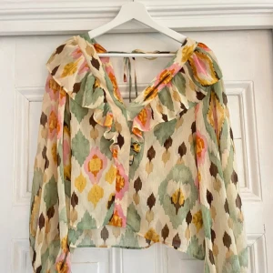 Färgglad blus  - Volanger öppen i ryggen