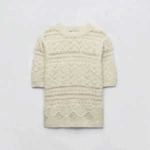 Beige stickad tröja - Snygg beige stickad tröja med ett detaljerat mönster. Tröjan har trekvartsärm och en rund halsringning. Perfekt för en stilren och mysig look.