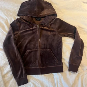 Brun velour hoodie från Juicy Couture - Säljer en brun velour hoodie från Juicy Couture med dragkedja och broderad logga på bröstet. Säljer för den kommer inte till användning och har inte används mer än 1 gång.  Ordinariepris 1,300kr💗