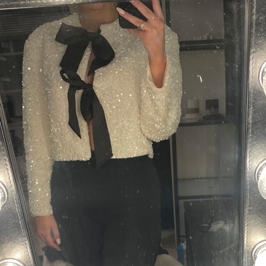 Vit glittrig tröja med rosetter framtill