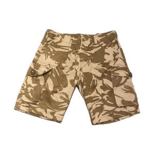 Beige öken camouflage shorts - Beiga öken camoflauge cargo shorts. Midjemått är 47 cm. Knappt använda så inget slitage alls